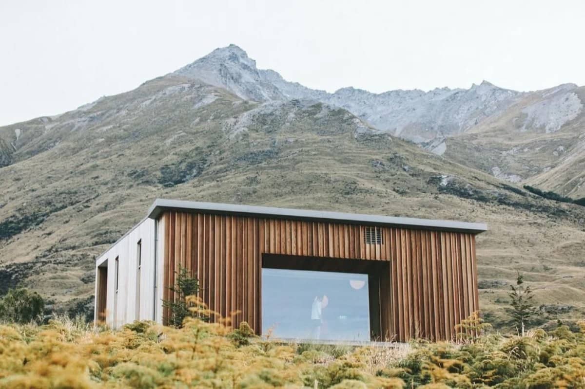 A cabin below a mountain